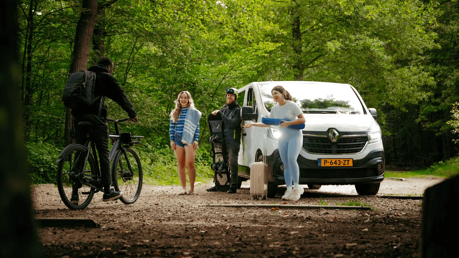 Groep mensen bij een bus in het bos tijdens een opname van KemX