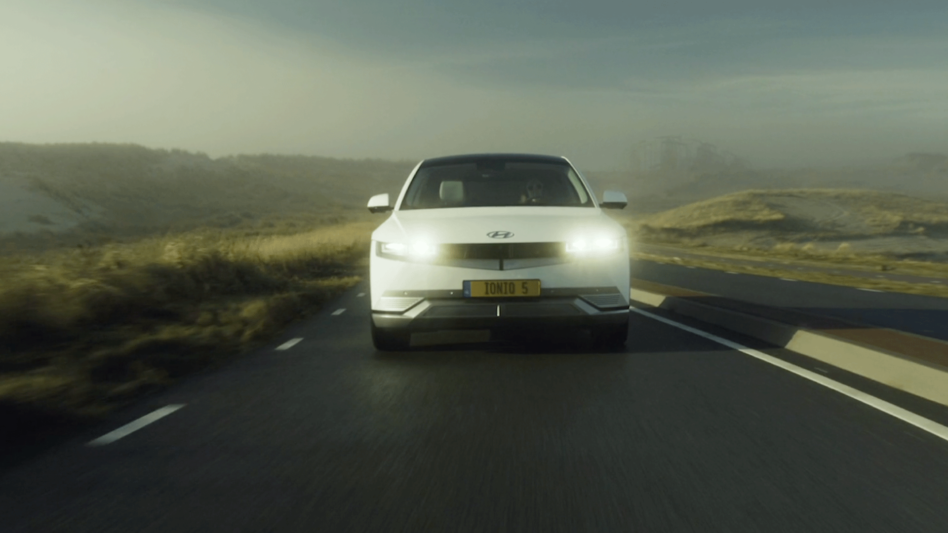 Witte auto in beweging op een weg tijdens een filmopname, voorbeeld van video laten maken