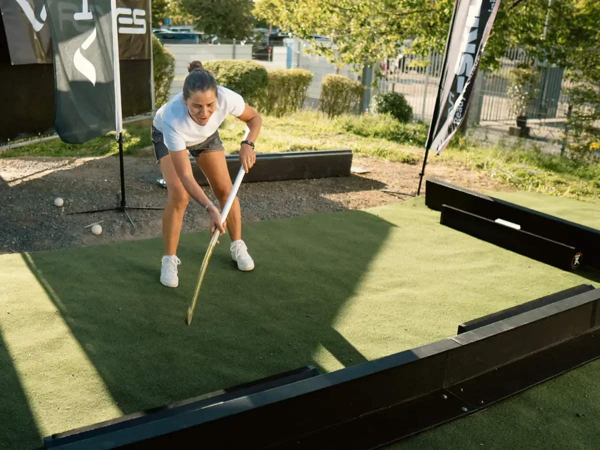 Bezoeker speelt op een klein veldje bij de X-Skills stand op het EK hockey 2025