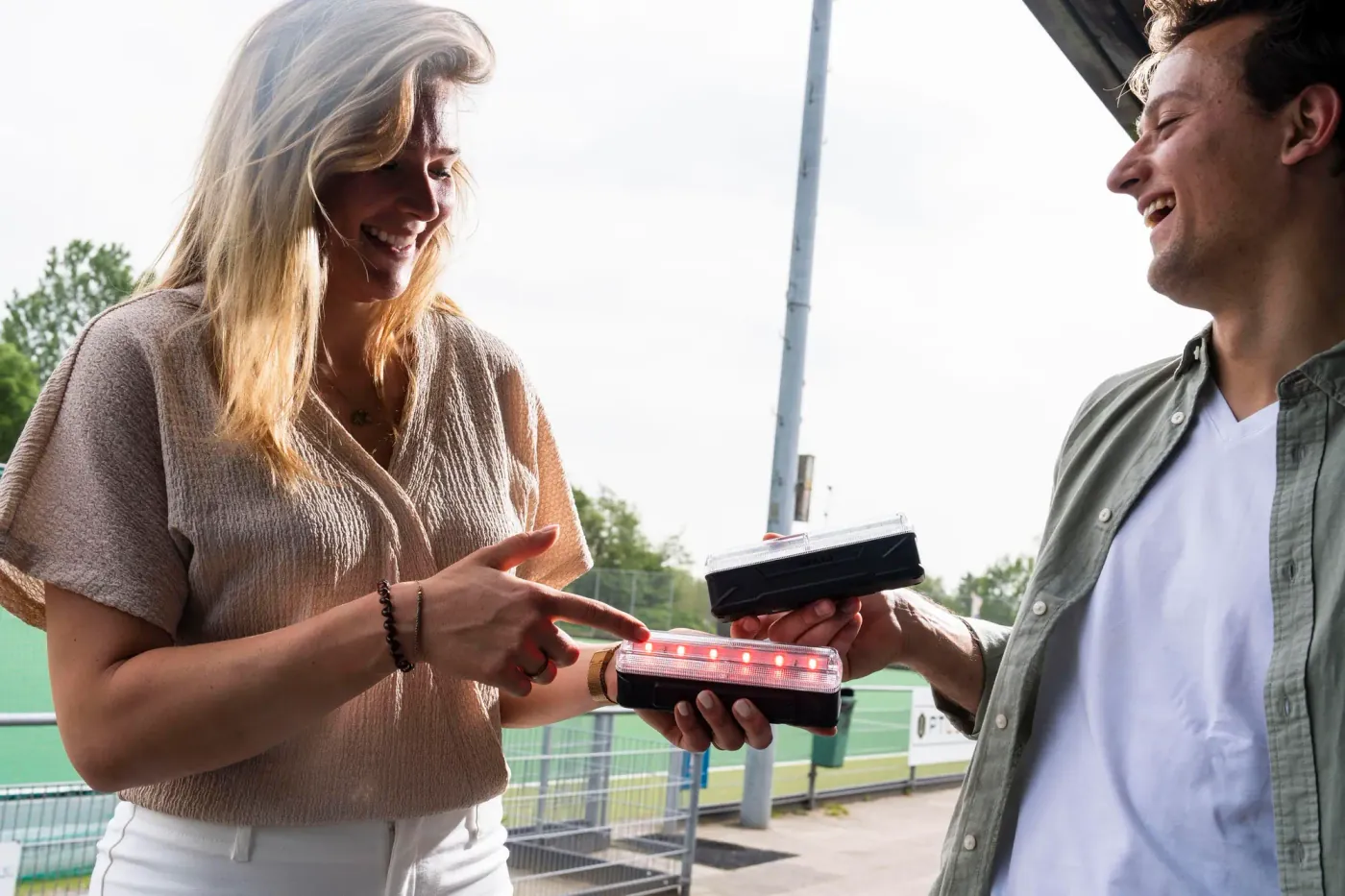 De oprichters van X-Skills, Bo-Jane Ladru en Michael Ladru, lachend bij een sportveld met een X-Skills beam